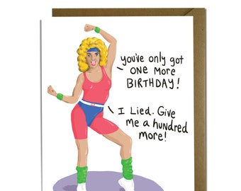 May include: A greeting card with a cartoon illustration of a woman in a pink leotard and leg warmers doing a fitness pose. The text on the card reads "You've only got one more birthday! I lied. Give me a hundred more!"