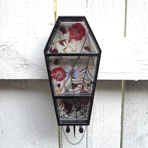 Floral spider coffin shelf