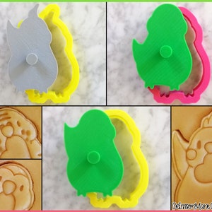 May include: A set of three cookie cutters in the shape of a cartoon bird. The cutters are made of plastic and are available in yellow, pink, and green. The cutters are shown with a cookie that has been cut out using the cutters.
