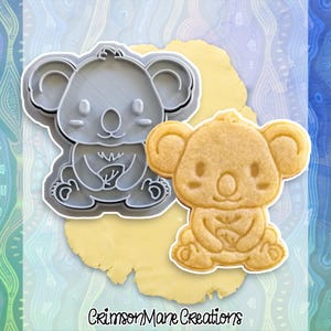 May include: A white ceramic mug with a black handle and the text "But First, Coffee" in a bold, black font. The mug is on a wooden surface. The mug is 10 cm tall.