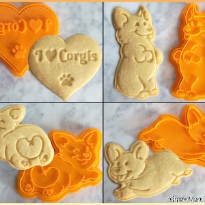 May include: A set of four cookie cutters, two in the shape of a heart with the text "I love Corgis" and "Corgis", and two in the shape of a Corgi dog. The cutters are orange and the cookies are light brown.