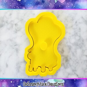 Pu&ograve; includere: Tagliapasta giallo brillante a forma di fantasma. Il tagliapasta ha una parte superiore arrotondata con un piccolo cerchio al centro e un fondo ondulato. Le parole "Crimson Mane Creations" sono in basso.