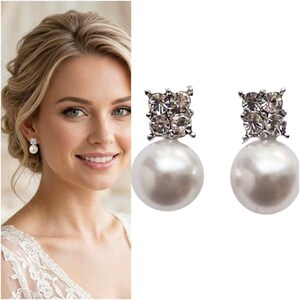May include: A pair of stud earrings featuring a square-shaped cluster of four clear crystals positioned above a single round white pearl. The earrings are silver-toned and designed with a post-back closure for secure attachment to the earlobe.