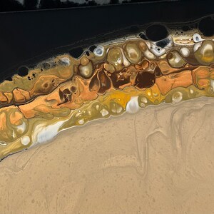 Könnte beinhalten: Abstraktes Gemälde mit schwarzem Hintergrund und einer fließenden Linie aus goldener, brauner und weißer Farbe. Die Farbe erzeugt ein Muster aus Kreisen und Wirbeln.