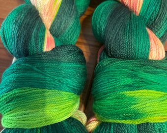 May include: Two skeins of green, yellow, and pink yarn with the label "Peak Season" on each skein.