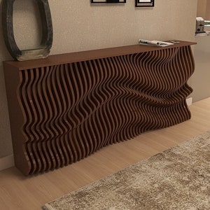 May include: A modern, wooden console table with a unique, wavy design. The table has a dark brown finish and is made of thin, vertical slats that create a flowing, organic pattern. The table is sitting on a light wood floor.