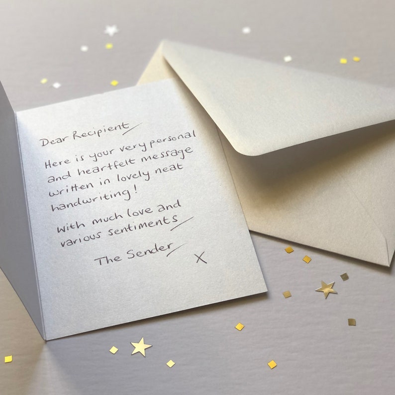 May include: An open greeting card with handwritten text, an envelope, and scattered gold confetti. The card reads "Dear Recipient, Here is your very personal and heartfelt message written in lovely neat handwriting! With much love and various sentiments, The Sender X."