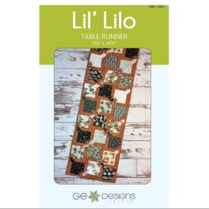 May include: A Lil' Lilo table runner pattern by GE Designs, measuring 13.5 inches by 40.5 inches. The rectangular runner features a patchwork design with various black, white, and green patterned fabric squares bordered by a solid orange frame.