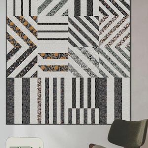 May include: A large quilt with a geometric design featuring bold black and white stripes, along with patterned fabric sections. The quilt has the text "BOLD STRIPES" at the top. The quilt is displayed on a wall with a green chair.