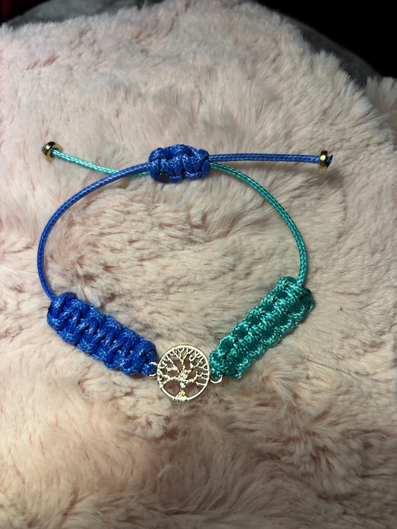Braided leather bracelet display on 5 different colors. Each with tree of life connector charm. Adjustable up top 10 inches.