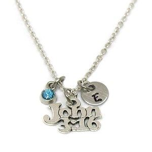 Puede incluir: Un collar de plata con un dije que dice "John 3:16" y un peque&ntilde;o cristal azul. El collar tambi&eacute;n tiene un peque&ntilde;o disco de plata con la letra "E" en &eacute;l.