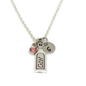 May include: Silver necklace with a charm of a gin bottle, a pink crystal, and a silver charm with the letter "S".