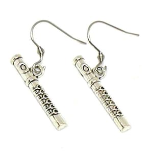 May include: A pair of silver dangle earrings featuring a flute design. The earrings have a hook closure.