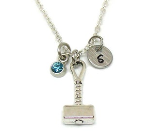 May include: Silver necklace with a small hammer charm, a blue crystal charm, and a silver charm with the letter 'S' on it.
