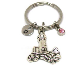 May include: Silver keychain with a lighthouse charm, a letter 'D' charm, and a pink rhinestone charm.