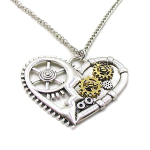May include: A silver necklace with a heart-shaped pendant featuring a steampunk design. The pendant is made of metal gears and cogs, with some gold accents.