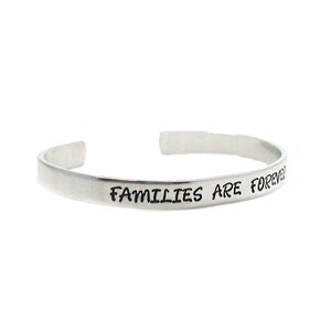 Peut inclure: Un bracelet en argent avec l'inscription "Les familles sont &eacute;ternelles".