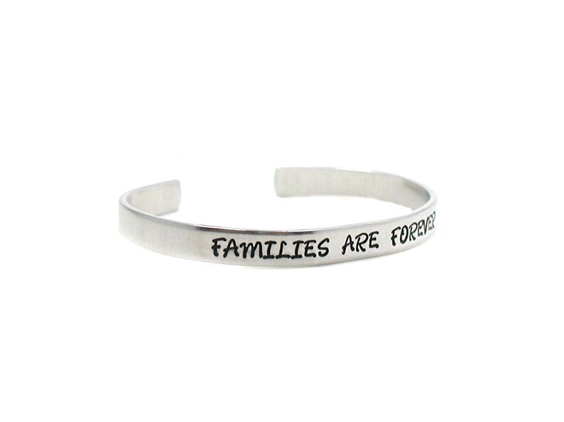 Peut inclure: Un bracelet en argent avec l'inscription "Les familles sont &eacute;ternelles".