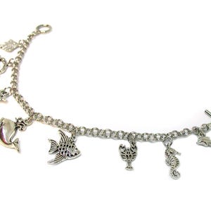 May include: A silver charm bracelet with a variety of sea creature charms, including a whale, a fish, a crab, a lobster, a seahorse, and a dolphin.