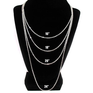 Puede incluir: Cuatro cadenas plateadas de diferentes longitudes mostradas en un maniqu&iacute; negro. Las cadenas miden 40,6 cm, 45,7 cm, 50,8 cm y 61 cm de largo.
