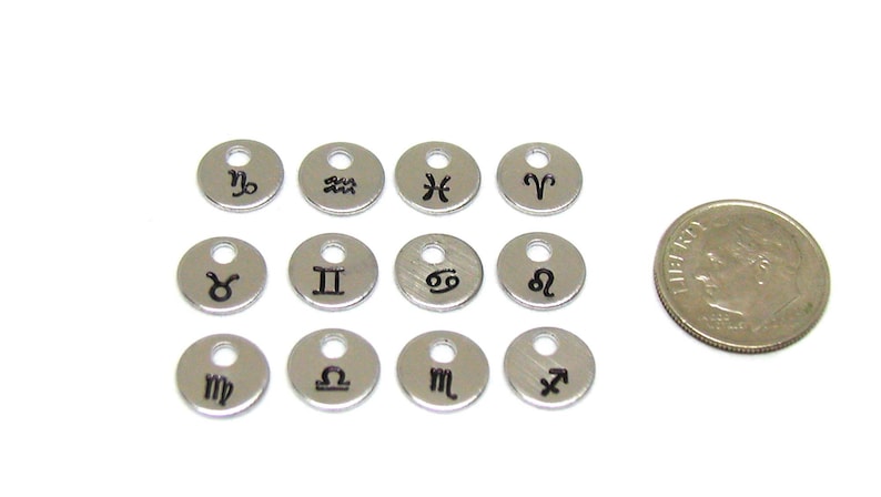 Puede incluir: Doce abalorios de plata con s&iacute;mbolos del zod&iacute;aco, cada abalorio tiene un peque&ntilde;o agujero para sujetarlo a un collar o pulsera. Los abalorios son aproximadamente del tama&ntilde;o de una moneda de diez centavos.