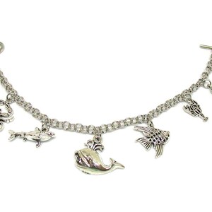 May include: A silver charm bracelet with a variety of sea creature charms, including a whale, a crab, a seahorse, and fish.