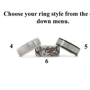 Op de afbeelding: Drie verschillende stijlen van herenringen. De eerste ring is een eenvoudige zilveren band. De tweede ring is een zilveren band met een zwarte inlay. De derde ring is een zilveren band met een textuurpatroon.