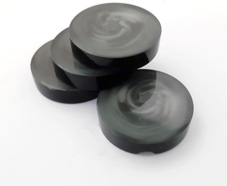 May include: Four black and white swirl coasters. The coasters are round and have a glossy finish.