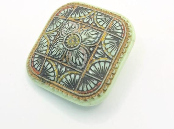 Mint green antique pressed glass brooch from early 1920s in a soft pastel mint green with a molded hand painted design 4 cm square
