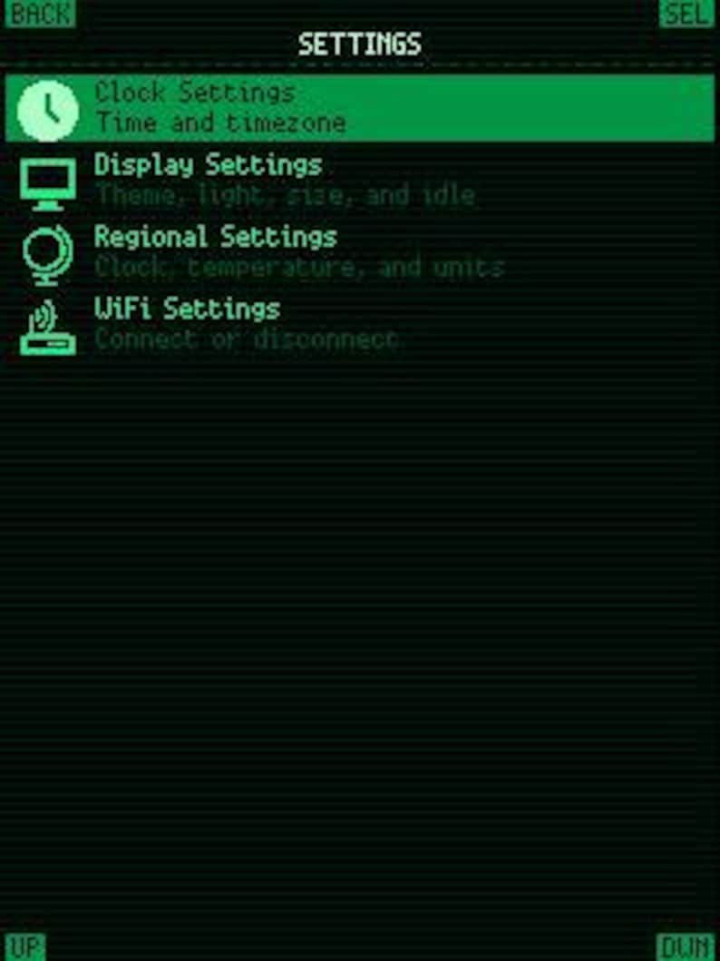 May include: A digital settings menu screen with a black background and bright green text and icons. The menu displays options for Clock Settings, Display Settings, Regional Settings, and WiFi Settings, with navigation buttons labeled BACK, SEL, UP, and DWN.