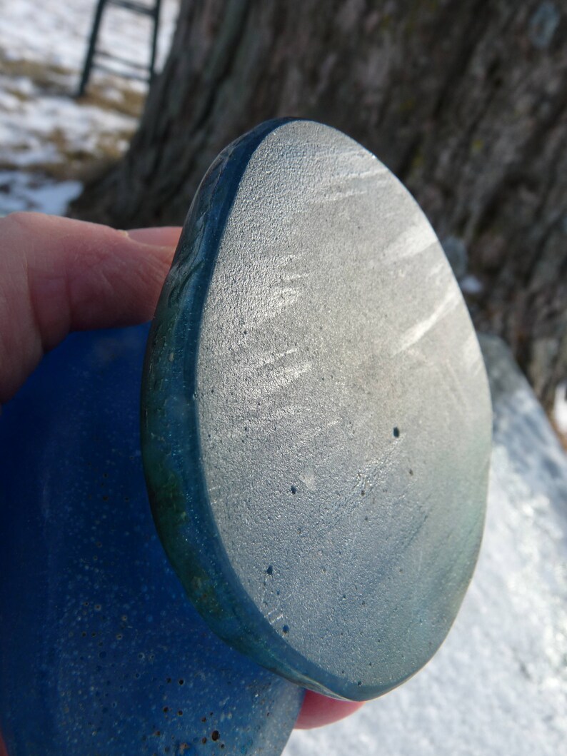 Pode incluir: Duas pedras de vidro azul lisas, redondas. A pedra superior &eacute; ligeiramente maior e tem um tom azul mais claro. A pedra inferior &eacute; de um azul mais escuro.