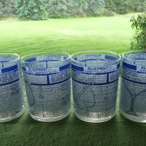 Könnte beinhalten: Vier klare Glasbecher mit blau-weißem Design. Jeder Becher zeigt eine Karte einer Stadt mit dem Text "Blueprint" und dem Stadtnamen.