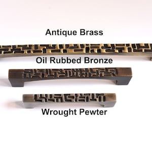 May include: Three cabinet pulls with a geometric pattern in antique brass, oil rubbed bronze, and wrought pewter finishes.