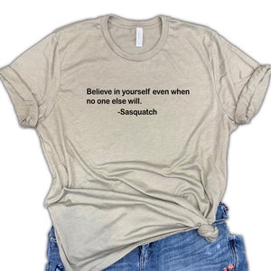May include: A light brown t-shirt with the text "Believe in yourself even when no one else will. -Sasquatch" printed on the front.