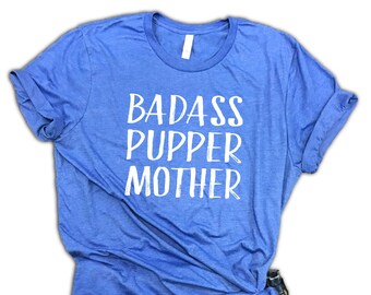 May include: A royal blue t-shirt with the text "BADASS PUPPER MOTHER" in white lettering.