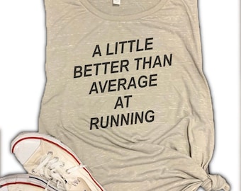 May include: A gray sleeveless shirt with the text "A little better than average at running" printed on it. The shirt is tied at the bottom and a pair of white sneakers are in the foreground.