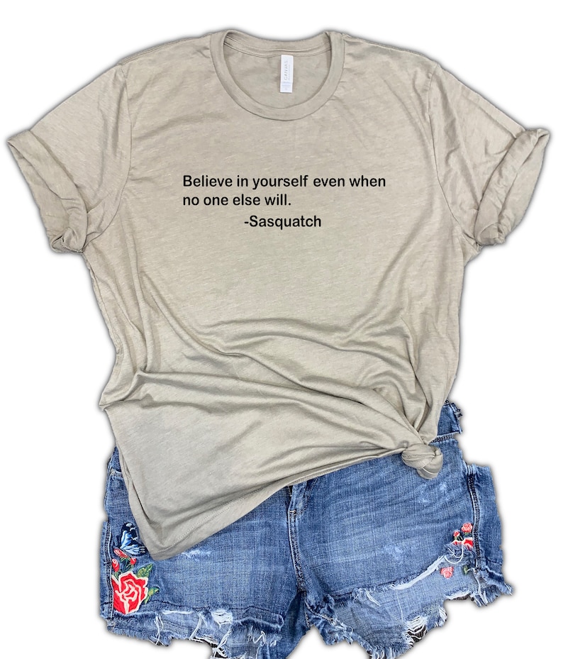 May include: A light brown t-shirt with the text "Believe in yourself even when no one else will. -Sasquatch" printed on the front.