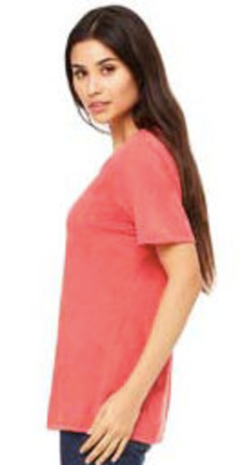 May include: A coral colored short-sleeved t-shirt made of a soft, comfortable fabric. The t-shirt is a relaxed fit and has a slightly distressed look.