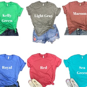 May include: Six different colored t-shirts with various text printed on them. The colors are Kelly Green, Light Gray, Maroon, Royal, Red, and Sea Green. The text on the shirts reads "Kelly Green", "Light Gray", "Maroon", "Royal", "Red", and "Sea Green".