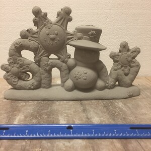 May include: A gray ceramic snowman figurine with a hat and a snowflake on top. The figurine is holding a snowflake in its right hand and the word "Snow" is spelled out in front of it.
