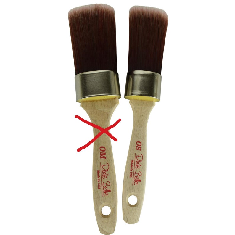 May include: Two Dixie Belle paint brushes with wooden handles and gold metal ferrules. The brush on the left is labeled "Dixie Belle OM Made in USA" and the brush on the right is labeled "Dixie Belle OS Made in USA".