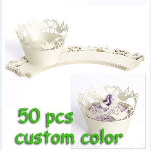 May include: Off-white cupcake wrappers with a decorative bird and heart design. The wrappers are stacked and ready for use. The image also includes the text "50 pcs custom color".