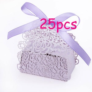 May include: A lavender gift box with a rose pattern cut-out design. The box is tied with a matching lavender ribbon. The text "25pcs" is displayed in pink on the ribbon.