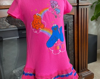 Size 3T Sesame Street short sleeve hot pink knit dress featuring Abby Cadabby, Elmo and Cookie Monster. I added a matching crocheted skirt.