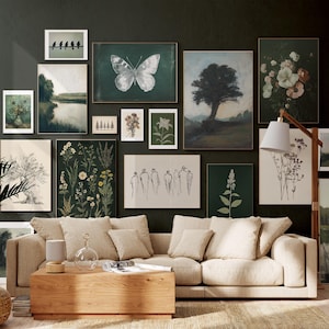 Puede incluir: Una sala de estar con un sofá beige y una mesa de café de madera. La pared detrás del sofá está decorada con una pared de galería de impresiones enmarcadas que presentan escenas de la naturaleza, ilustraciones botánicas y arte abstracto.