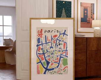 May include: A framed print of a colourful map of Paris with the word "Paris" in bold, blue letters. The map is surrounded by a white mount and a wooden frame.