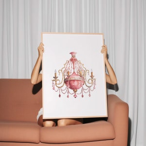 May include: A framed print of a pink and gold chandelier with crystal accents. The chandelier is depicted against a white background.