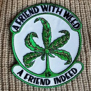 May include: A white patch with green embroidered marijuana leaf and the text "A friend with weed is a friend indeed" in black.