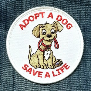 May include: White embroidered patch with red text that reads "Adopt a Dog Save a Life". A cartoon image of a brown dog with a red leash is in the center of the patch.