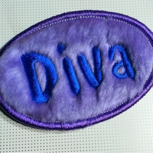 May include: Purple fuzzy oval patch with the word "Diva" embroidered in blue thread.